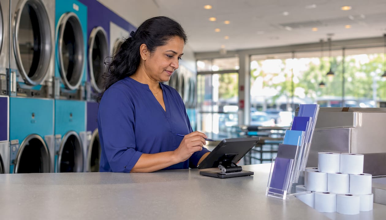 Laundromat owner using POS terminal