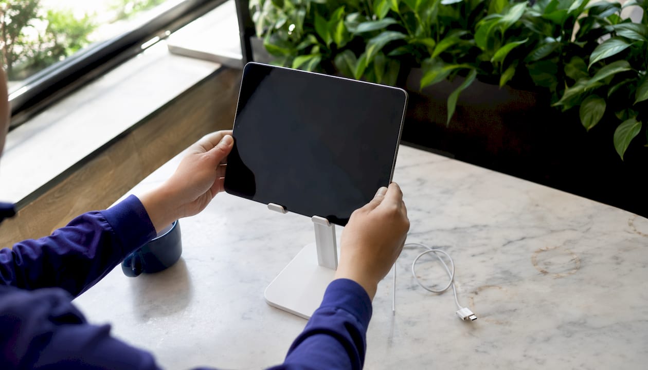 Hands setting up iPad terminal on counter