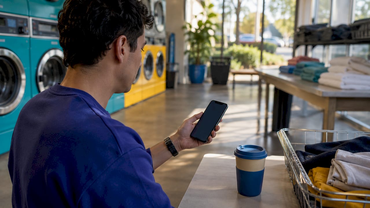 Close-up of smartphone usage for laundromat device management