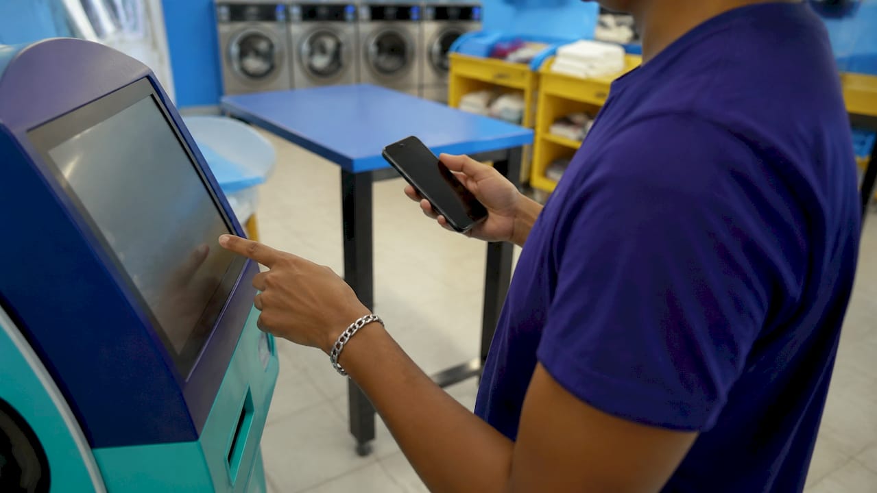Customer using automated complaint app in laundromat