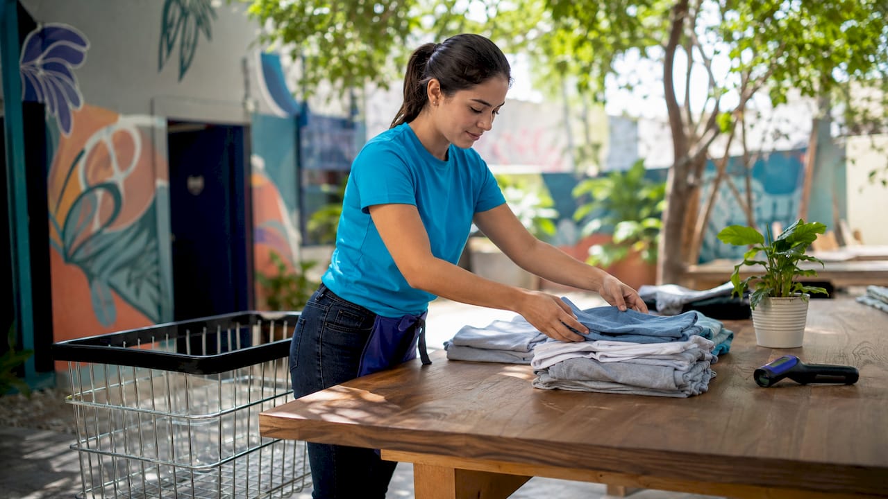 Attendant sorting laundry in automated processing hub